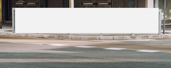 Long empty white billboard mounted on sidewalk at city street front view outside © Bonsales