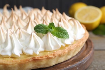 Delicious lemon meringue pie decorated with mint on table, closeup