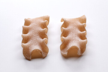 small composition of whole durum wheat pasta on a white background