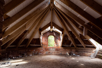 Old ruined attic with red bricks and wooden planks
