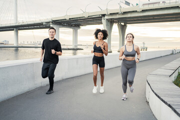 A group of people are runners in sportswear. Friends workout fitness running in the city. Fitness watch on hand.