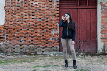 Women in front of brick wall and red door waiting