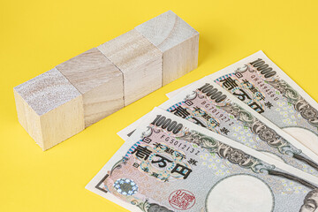【合成素材】4つの木製のブロックと1万円札