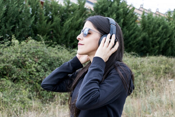 Women closeup outdoors with headphones and sunglasses