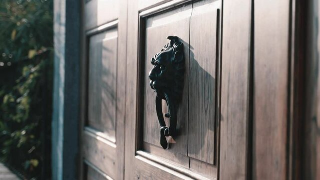 Mediterranean mystic lions door knob with a ring on a wooden doors gate architecture italian lombardy of famous Villa Balbianos side entrance at lake como italy - cinematic