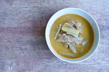 spicy boiled slice banana blossom with chicken in curry and coconut milk soup on bowl