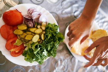 Women hands lay out sliced fruits on a plate. Top view. High quality photo