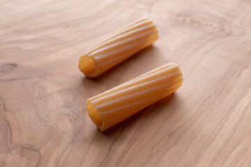 whole wheat durum wheat pasta on wooden background