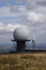 a view of the radar station at Titterstone Clee summit with the sky clear blue with fluffy clouds