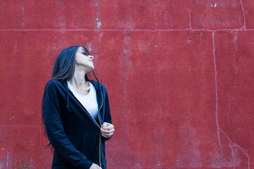 Women with semi open sweater in front of red wall