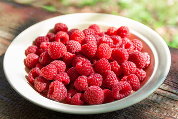 Raspberry berries. Raspberries in a bowl. Selective focus. Shallow depth of field. Blurred background