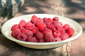 Raspberry berries. Raspberries on a plate. Selective focus. Small depth of field. Blurred background
