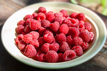 Raspberry berries. Close-up of raspberries in a plate. Selective focus. Shallow depth of field. Blurred background