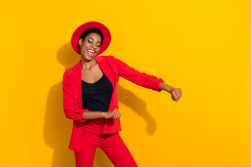 Photo of cute funky short hair person dressed red suit cap smiling dancing isolated yellow color...