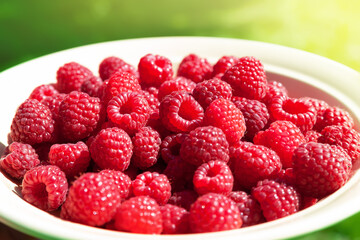 Raspberry berries. Close-up of raspberries in a plate. Selective focus. Small depth of field. Blurred background