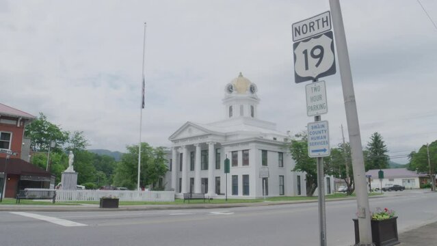 Highway 19 sign and city building in Bryson City, North Carolina in slow motion on overcast day in summer