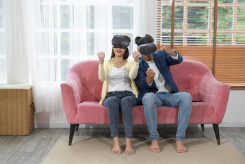young couple using virtual reality headset playing game in living room at home.concept technology...