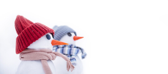 Two little snowmans in a cap and a scarf on snow in the winter. Christmas card, copy space