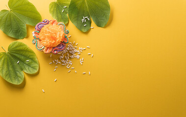Happy Dussehra. Yellow flowers, green leaf and rice on yellow paper background. Dussehra Indian...