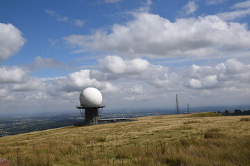 a view of the radar station at Titterstone Clee summit with the sky clear blue with fluffy clouds