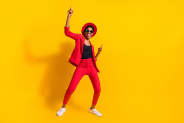 Photo of excited cool short hair person dressed red suit cap spectacles dancing pointing empty space isolated yellow color background