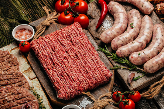 Raw meat products, different parts of the body. minced beef meat kebabs, pork, beef, chicken on a wooden background. top view