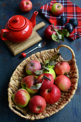 Still life with red apples in a basket and a teapot
