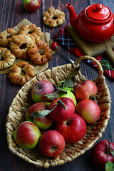 Naklejka na ściany i meble Fragrant red apples and homemade cakes with apples on a wooden background.