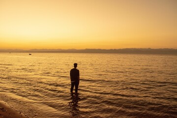 Man standing on the beach during sunset