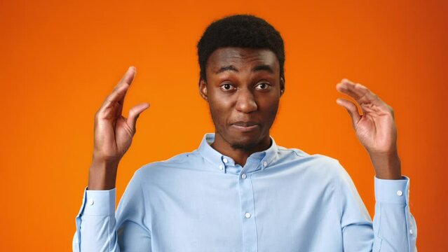Young african man showing bla-bla gesture against orange background
