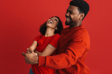 Black young couple laughing while dancing together