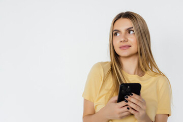 Naklejka premium Photo of a young woman posing isolated over white wall background using mobile phone.