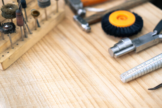 jewelry handmade by experienced goldsmiths with simple tools on wood background top view