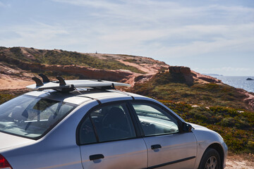 Fototapeta na wymiar Surfboard on car top, waiting for the waves at summer sunny day