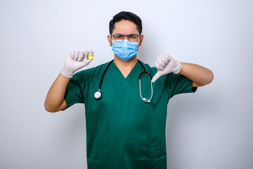 Serious asian doctor holding urine pot while showing thumb down, showing bad result test