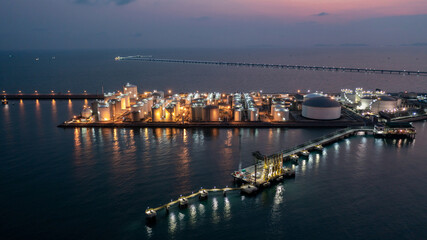 Obraz premium Aerial view chemical storage tank on sea at oil terminal station at night, Chemical plant petroleum and petorchemical product, Chemical industry plant in refinery at night,