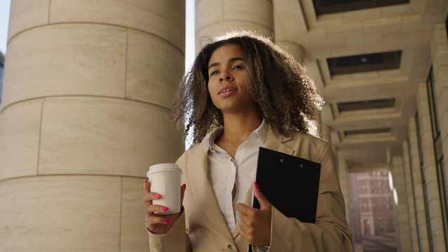Young biracial woman walks imagining herself model by office