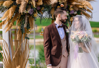 Firt meeting of newlyweds outdoors near wedding altar with landcape