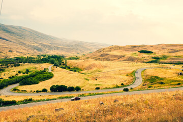 Fototapeta na wymiar Automobile drive in countryside serpentine road outdoors in nature with scenic mountains panorama. Travel road trip in caucasus- Armenia