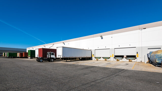Lined up Semi trucks on a parking lot at logistics warehouse
