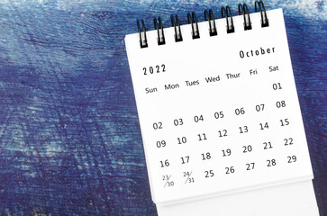 The October 2022 Monthly desk calendar for 2022 year on old blue wooden background.