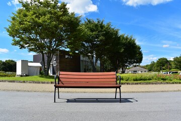 Fototapeta na wymiar 公園のベンチ。夏の青空、白い雲。