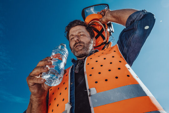 Arbeiter in Sicherheitskleidung schwitzt in der Sonne