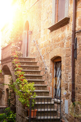 Picturesque building in medieval town in Tuscany, Italy. Old stone walls and plants