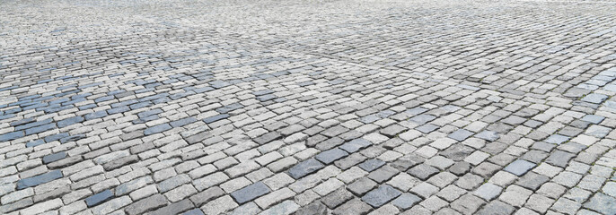 The texture of a stone old pavement with a perspective.