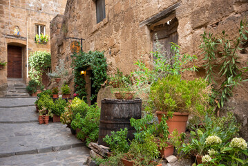 Picturesque building in medieval town in Tuscany, Italy. Old stone walls and plants