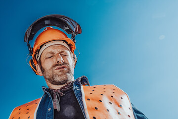 Arbeiter in Sicherheitskleidung schwitzt in der Sonne