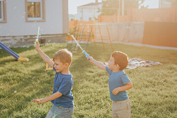 Children blow bubbles in the backyard.