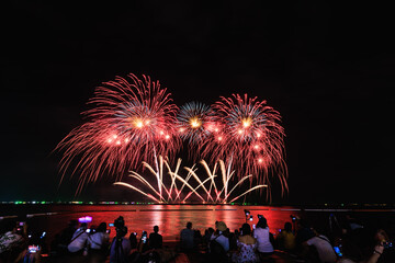 Obraz premium PATTAYA, CHONBURI, THAILAND, - NOVEMBER Beautiful lights at the night, colorful fireworks, at Pattaya International Fireworks Festival and silhouette Group of people tourist