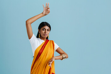 Portrait of young beautiful indian woman in traditional dress dancing